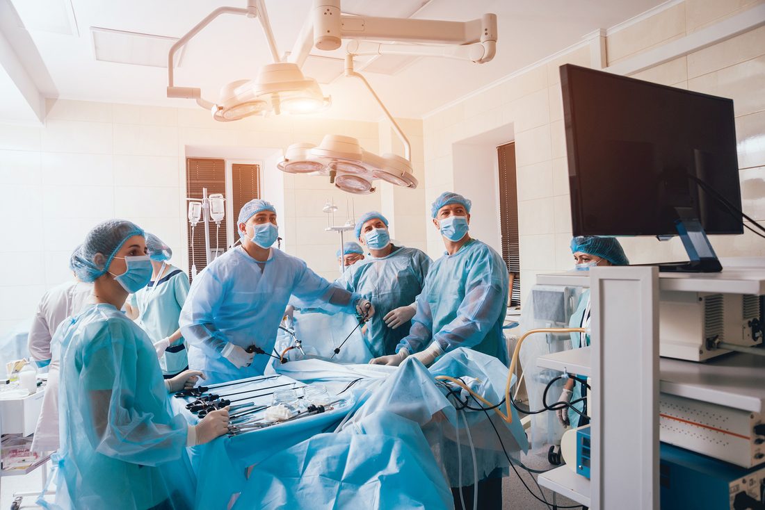 A surgical team in gowns and masks working around the table in an operating room